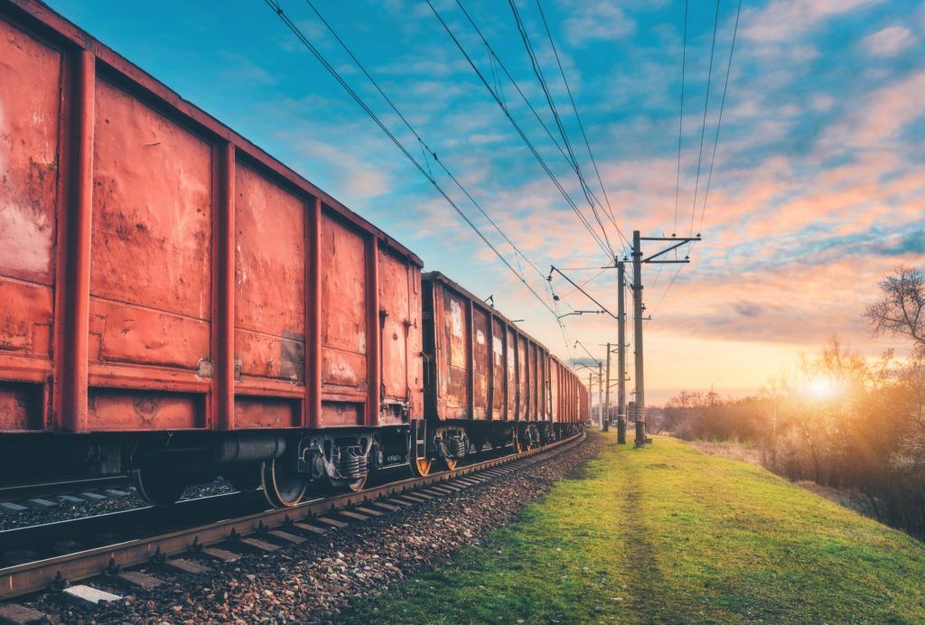 Red cargo wagons and train on railway station